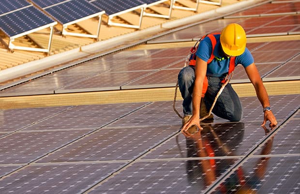 Person fixing solar panels