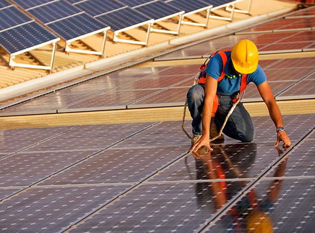 Person fixing solar panels