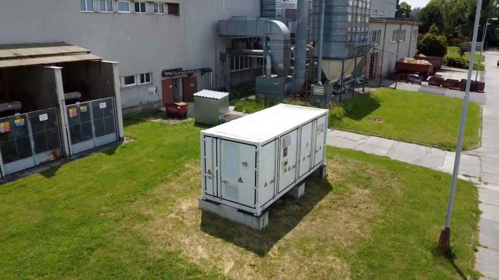 Wattstor energy storage container deployed at the TON project location with industrial facility in the background.