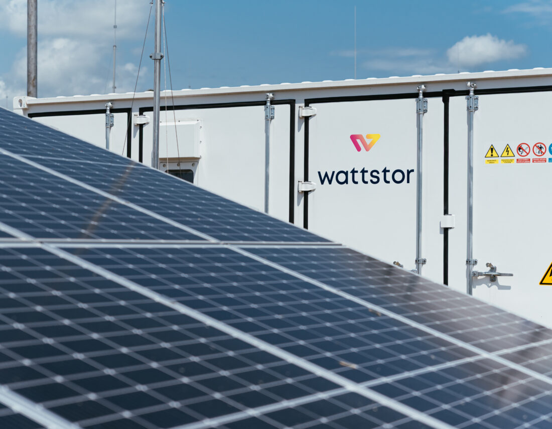Detail photo of photovoltaic panels with a Wattstor energy storage container deployed at the TON project location.