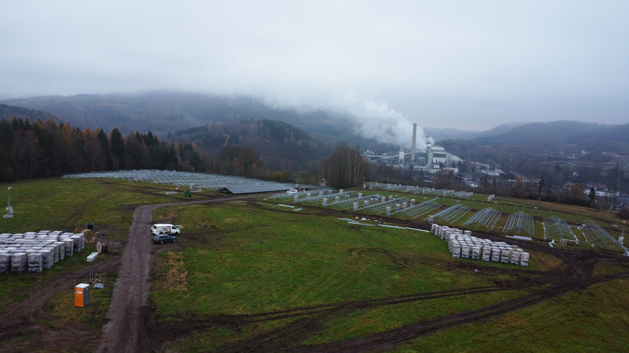 Rozsáhlá stavba energetického projektu KEROSIN a Wattstor na Trutnovsku, s instalovanými konstrukcemi pro fotovoltaiku a průmyslovým areálem v pozadí.